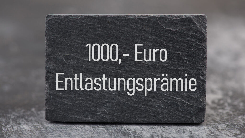 1.000 EUR Entlastungspraemie. zu sehen sind ein Stein mit der Aufschrift 1000,– Euro Entlastungsprämie.