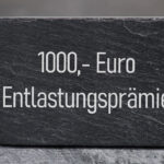 1.000 EUR Entlastungspraemie. zu sehen sind ein Stein mit der Aufschrift 1000,– Euro Entlastungsprämie.