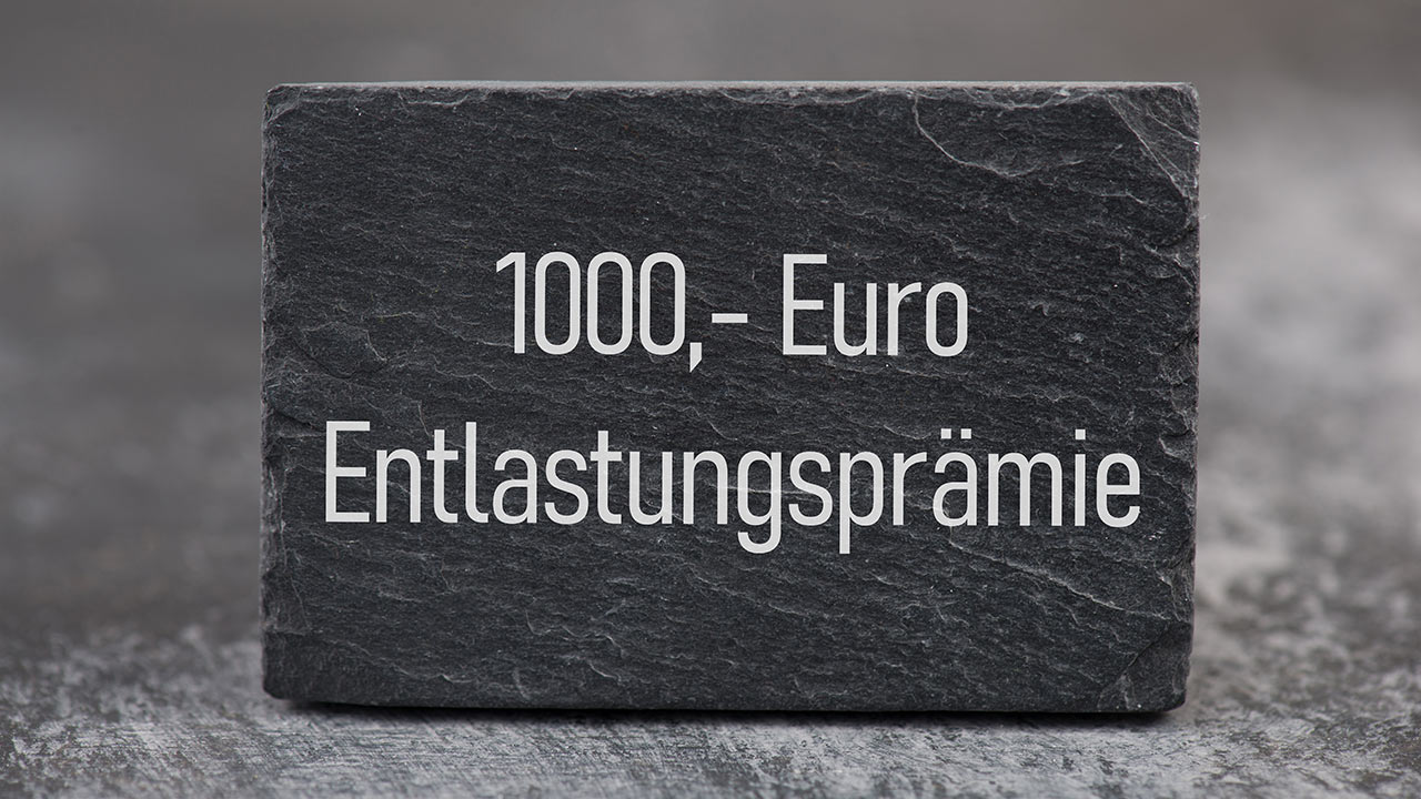 1.000 EUR Entlastungspraemie. zu sehen sind ein Stein mit der Aufschrift 1000,– Euro Entlastungsprämie.