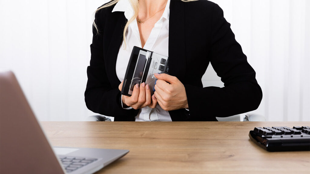 Diebstahl am Arbeitsplatz | Eine blonde Frau, die Arbeitsmaterial am Arbeitsplatz stiehlt.