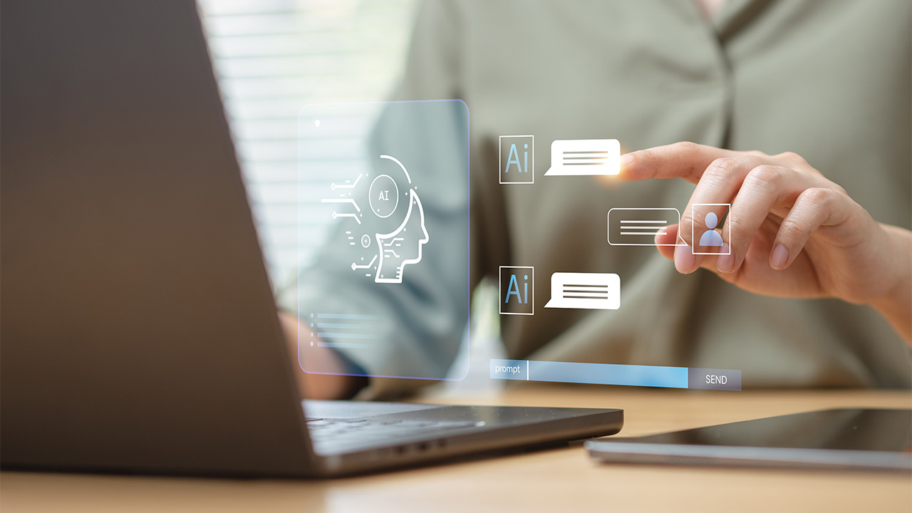 Künstliche Intelligenz am Arbeitsplatz – was erlaubt ist und was nicht! - bild ki am arbeitsplatz 1 Ein Mitarbeiter sitzt am Laptop und gibt einen Prompt für die KI ein.