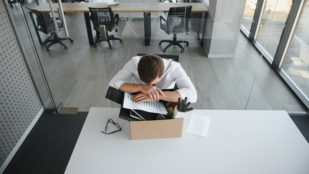 Ein deprimierter Arbeitnehmer, dem gekündigt wurde, packt seine Sachen zusammen.
