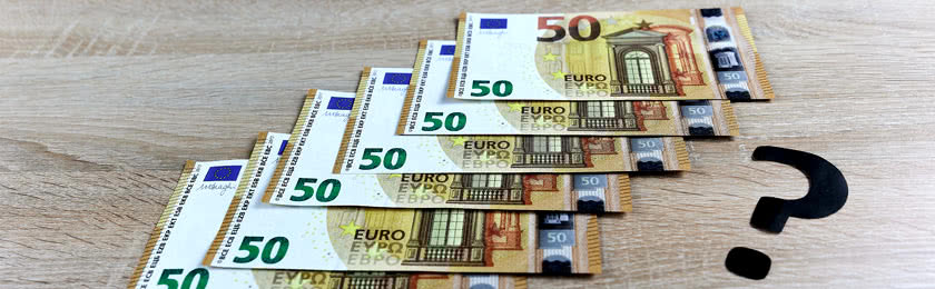 Mehrere 50€ Scheine und ein Fragezeichen sind auf einem Tisch abgebildet. Ob man die Abfindung bekommt, wenn man selbst kündigt?