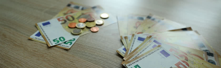 Links liegen nur zwei 50€ Scheine und Münzen, rechts liegen mehrere 50€ Scheine, die symbolisieren wie viel Abfindung einem zu steht.